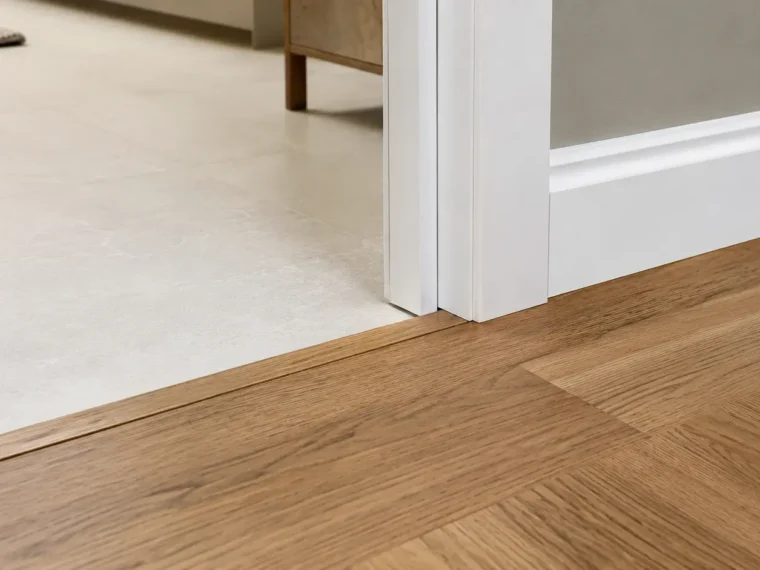 Clean transition between oak hardwood and large porcelain floor tile